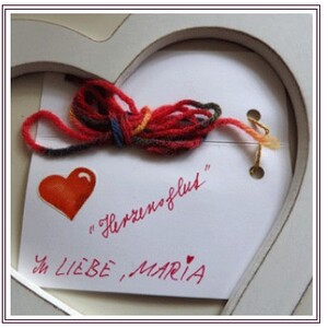 Symbolisches Herz mit glühender Herzensenergie und der Wolle von einem handgestrickten Schal